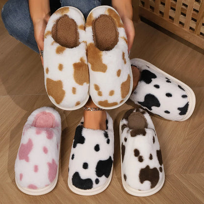 Cozy cow-print plush slippers with soft, fluffy material and non-slip soles for warm, comfortable indoor wear