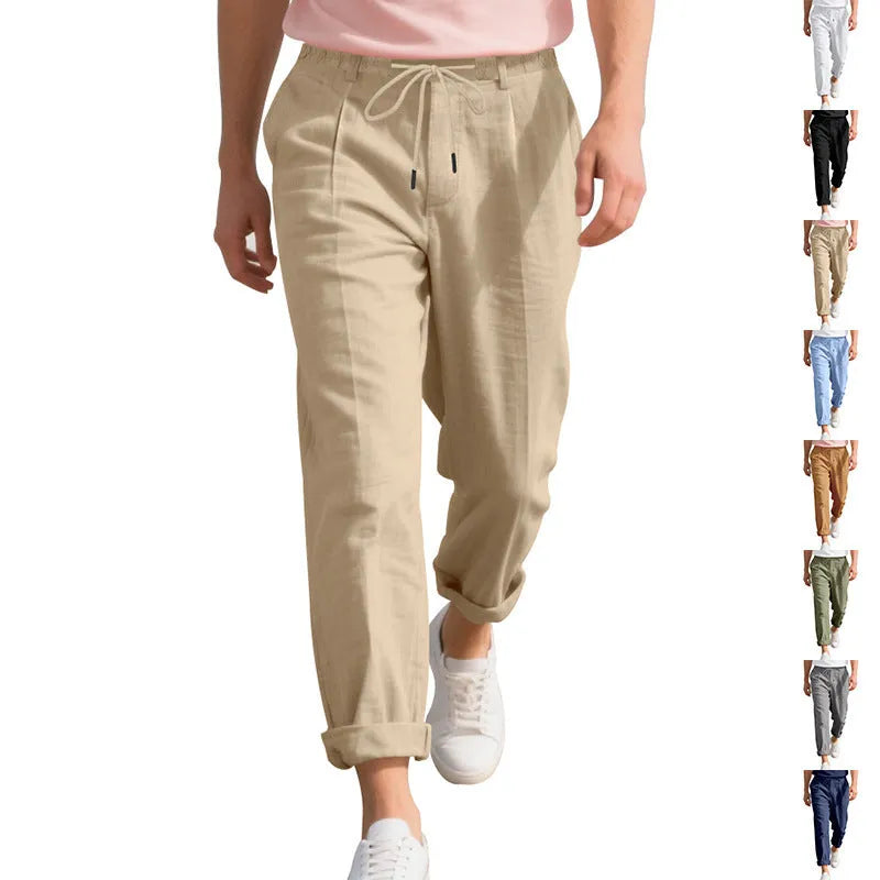 Men's light beige linen trousers with drawstring waist and straight-leg design laid flat
