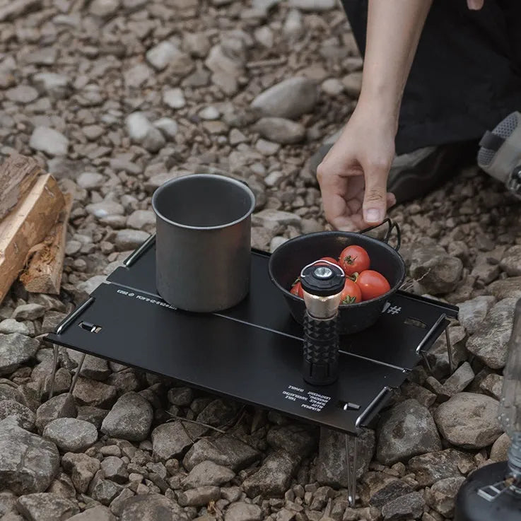 Aluminium alloy camping folding table shown in a folded position, available in black or grey colour.