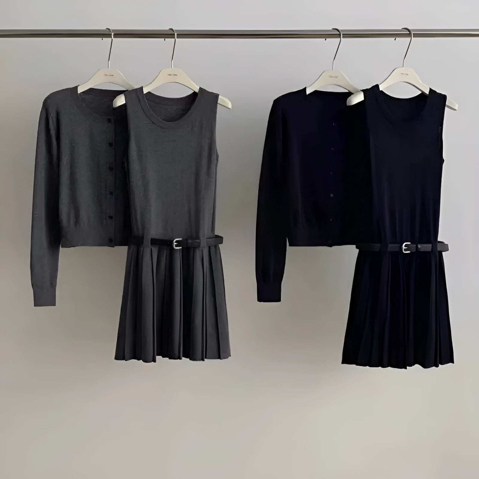 Women's black knitted vest skirt and long-sleeved cardigan two-piece set with pleats and a belt.