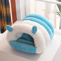 Blue enclosed cat bed with removable fleece liner, shown in a home setting.