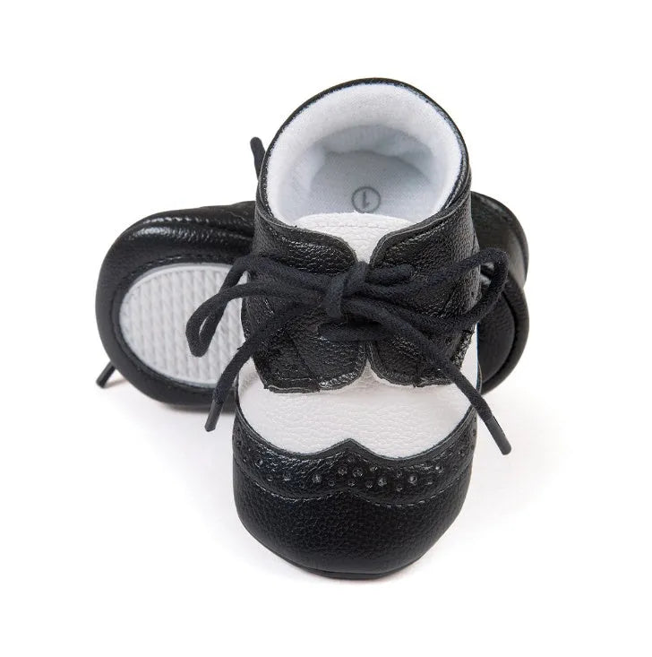 Vintage-style soft-soled baby shoes in synthetic leather, shown in light brown.