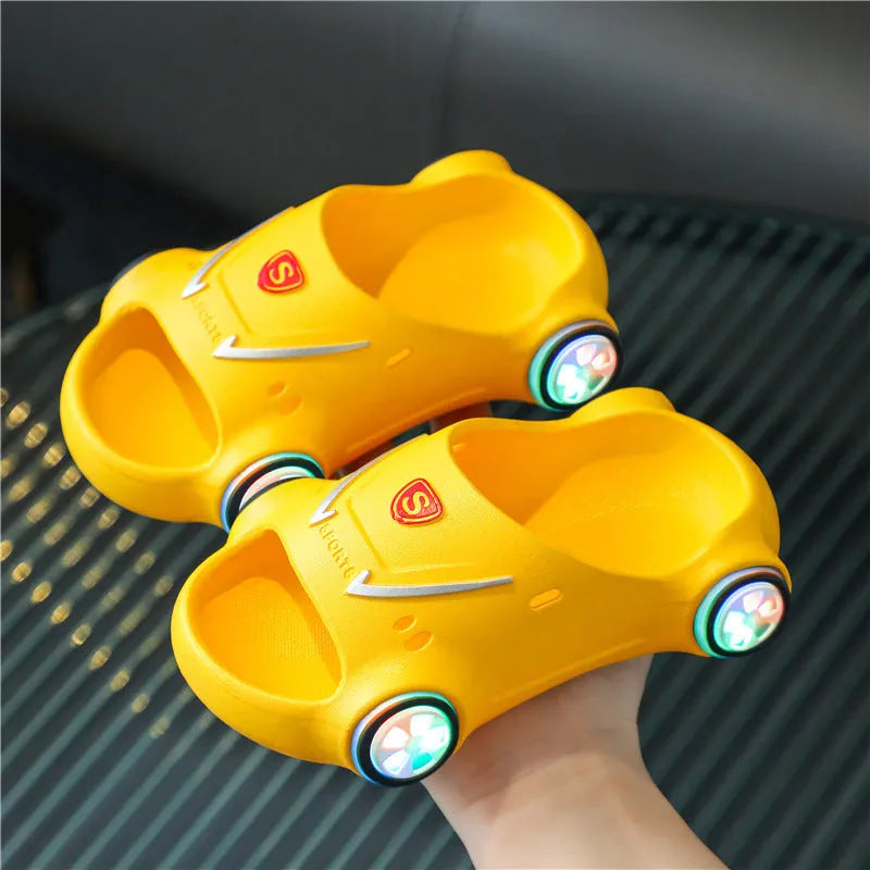 Children's luminous cartoon car design sandals with anti-slip soles on a blue background.