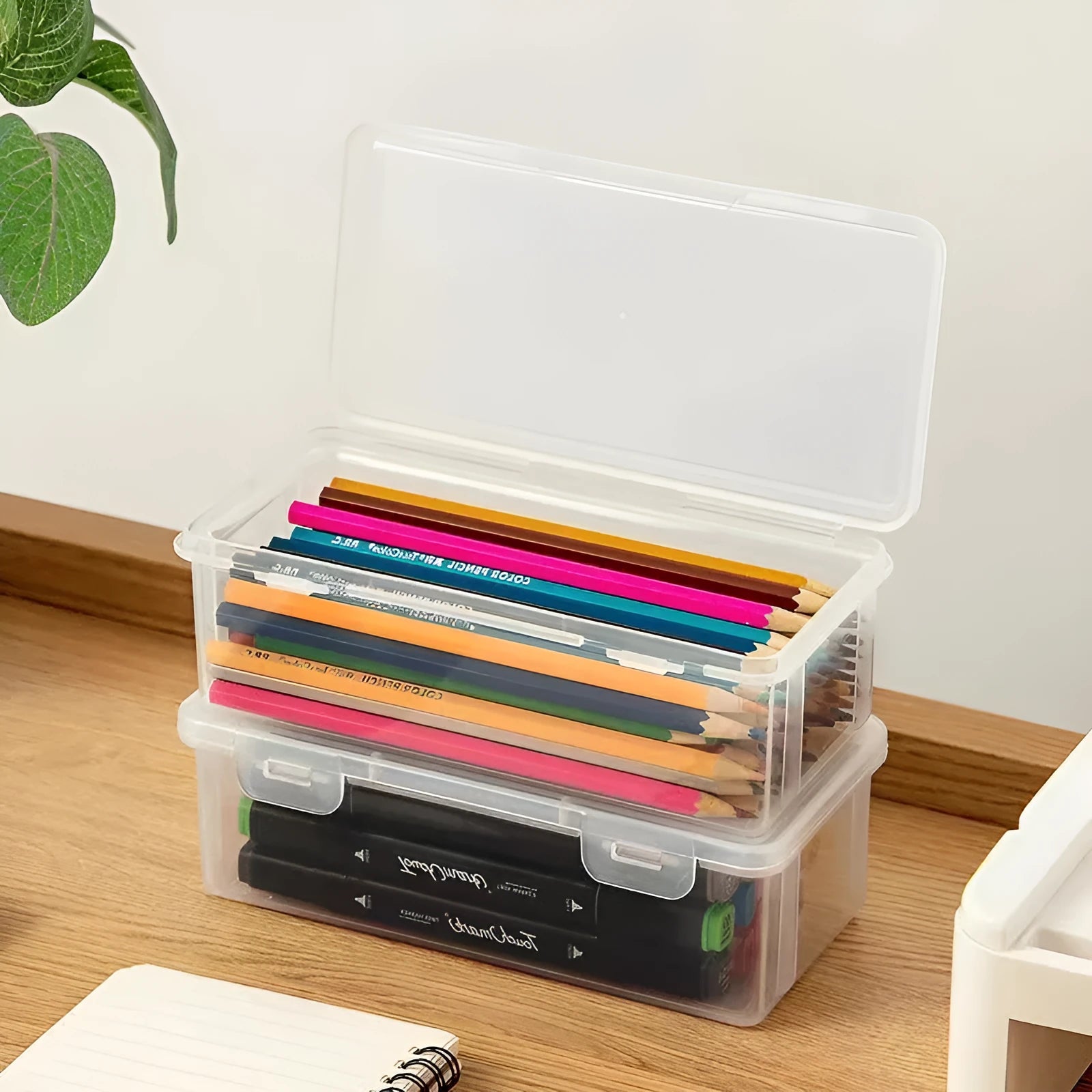 Transparent plastic pencil storage box for stationery organisation with visible drawing supplies inside
