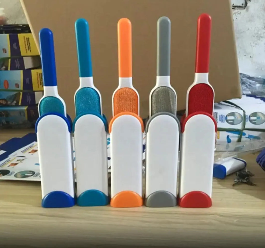 Blue self-cleaning pet hair remover brush with double-sided roller next to its cleaning base.
