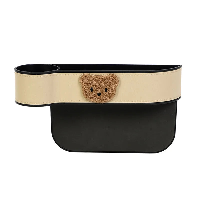 Leather car seat gap storage box with a cartoon bear design, shown hanging between vehicle seats.