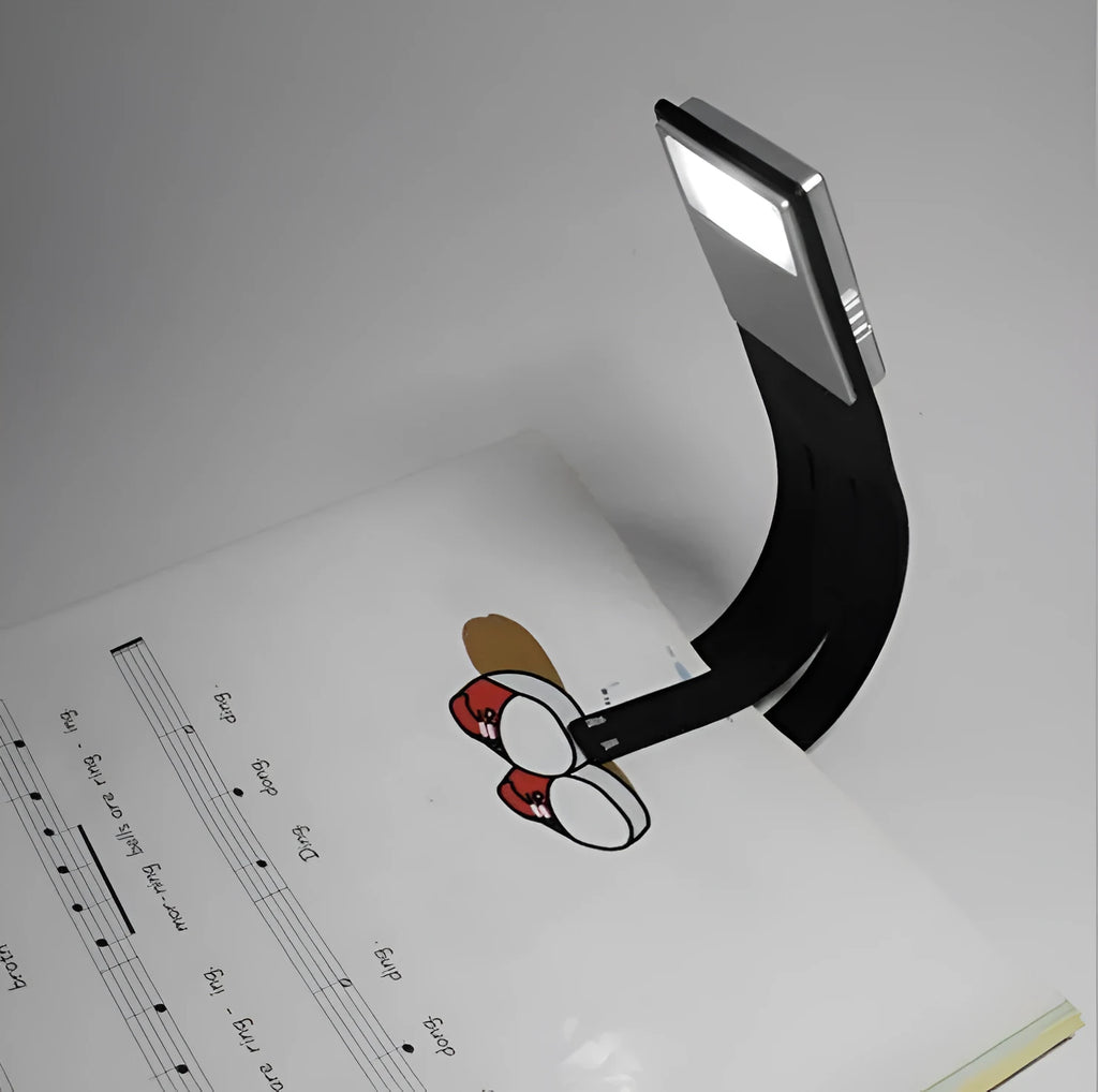 Black folding LED reading lamp clipped to a Kindle e-reader showing adjustable brightness settings