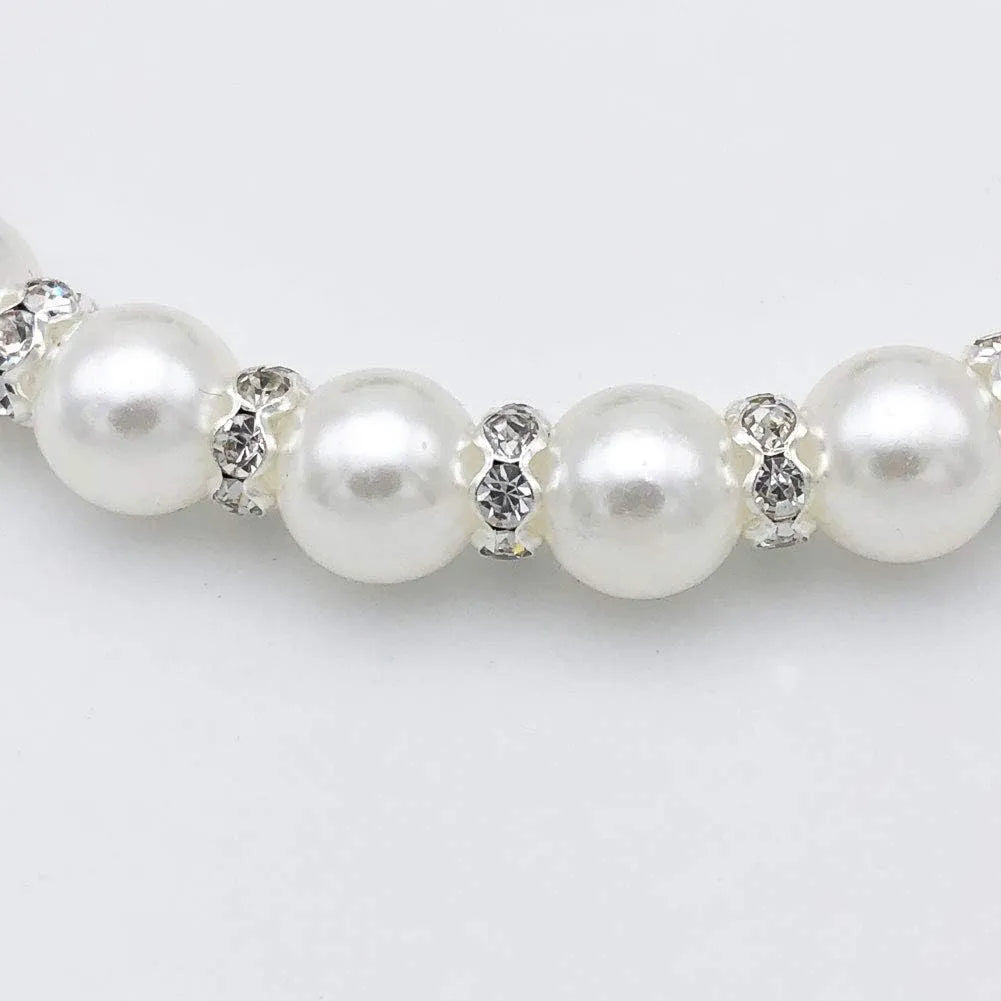 Small dog wearing adjustable pearl and rhinestone necklace with soft ribbon bow in pink colour