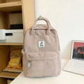 Retro hand-carrying backpack in light pink with breathable fabric, document pocket, and sewing line details for school use.