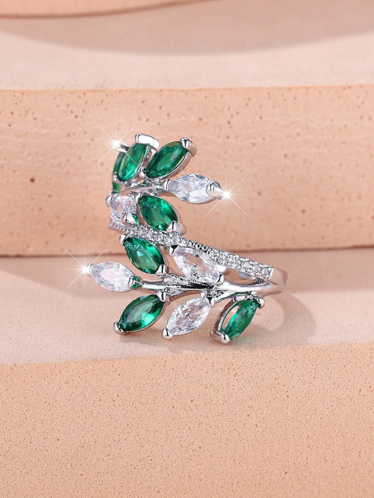 Adjustable copper leaf ring with a horse eye zircon stone in multiple colour finishes on a neutral background.
