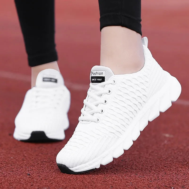 Women's running shoes in black, pink, and white with a fly weaving upper and wear-resistant outsole.