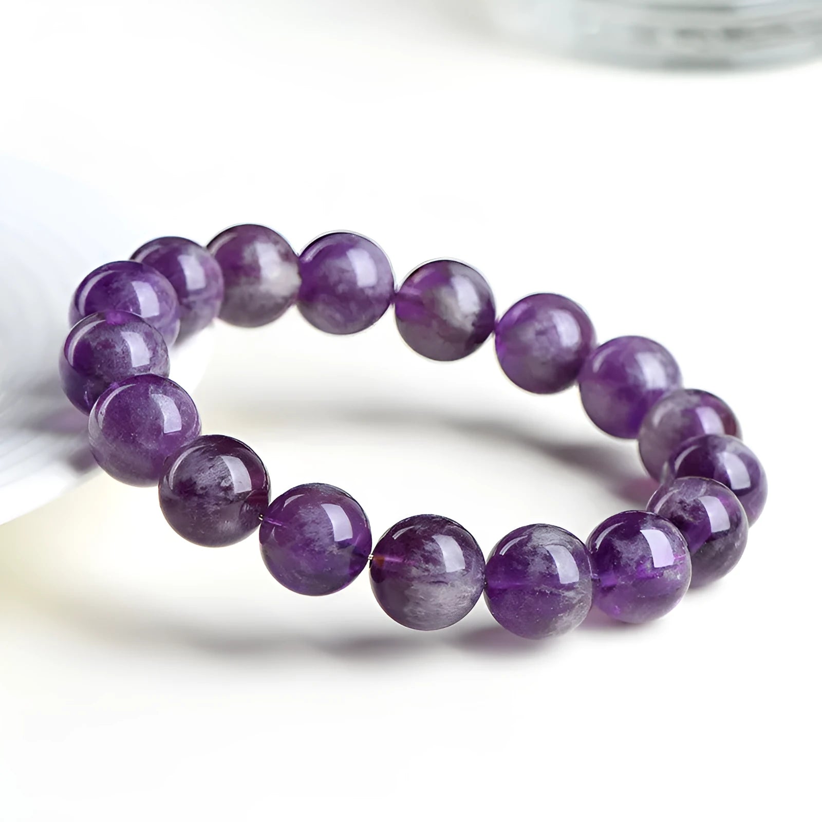 Natural Feather Amethyst purple crystal bracelet with scattered geometric beads on a wrist.