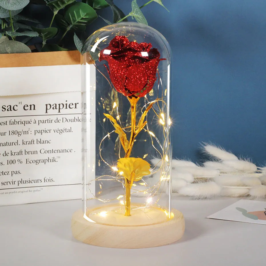 Glass dome covering a red eternal rose with coiled battery-powered LED lights on bendable copper wire.