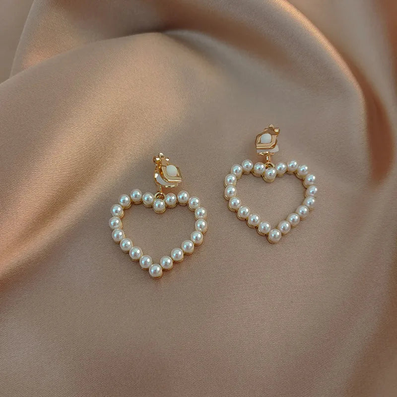 Heart shaped ear clip earrings for women with imitation pearl heart detail and retro round face, 1 pair