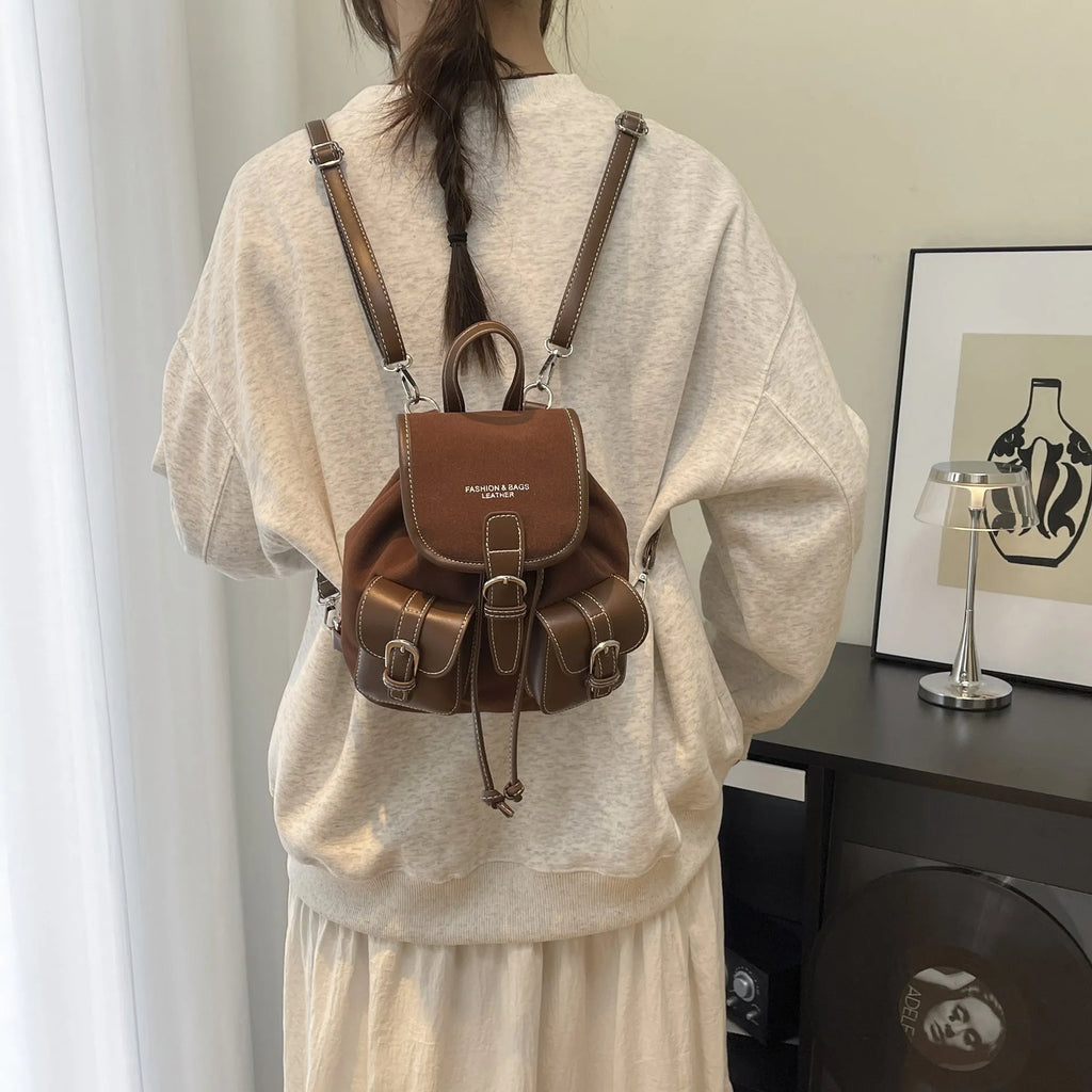 Urban simplicity PU backpack in brown with contrast stitching and clamshell opening, on a flat surface