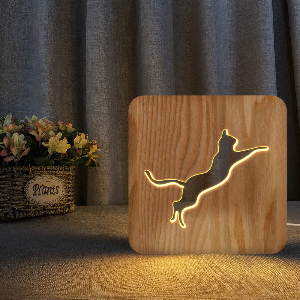 Solid wood 3D night light with hollow cat design on a table