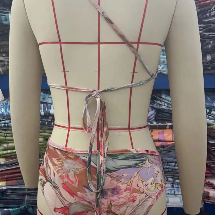 Rose gold patterned women's one-piece swimsuit on a hanger.