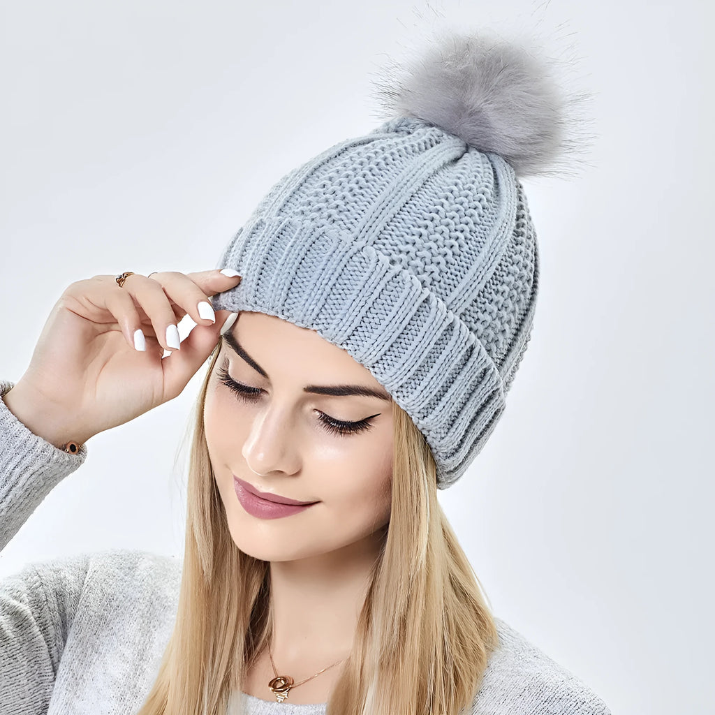 Women's satin-lined skull beanie hat with a faux fur pom pom in wine red colour.