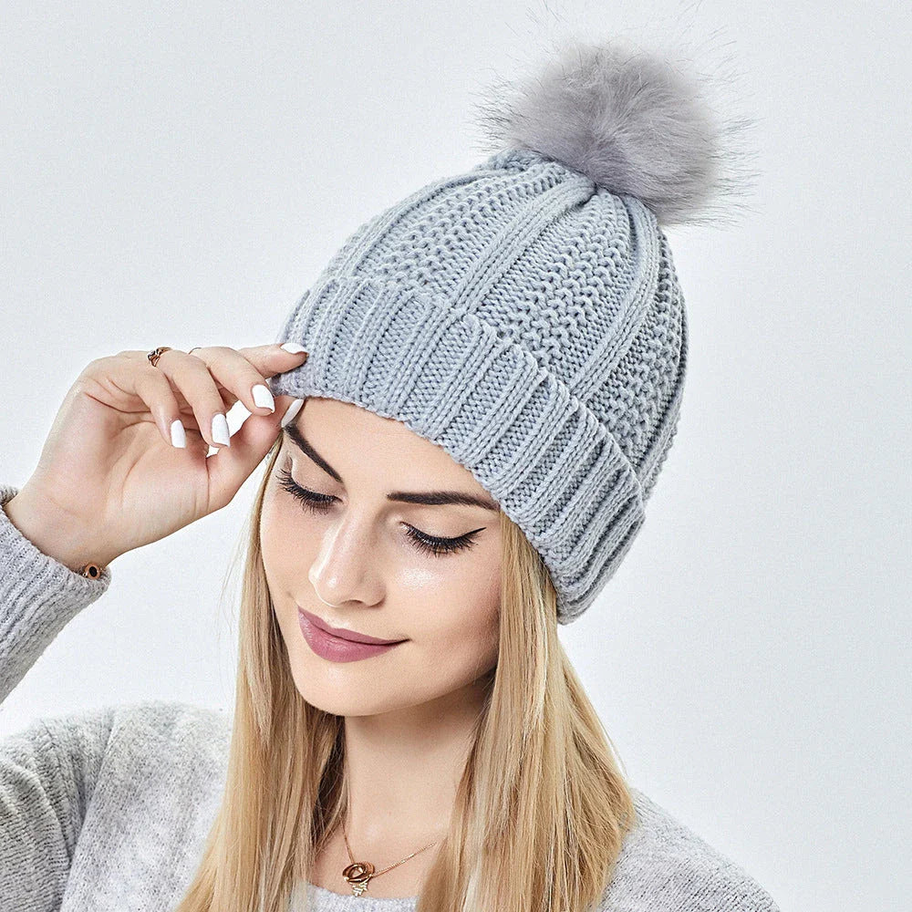 Cozy knit beanies with satin lining, paisley pattern, and faux fur pom poms in a variety of colors