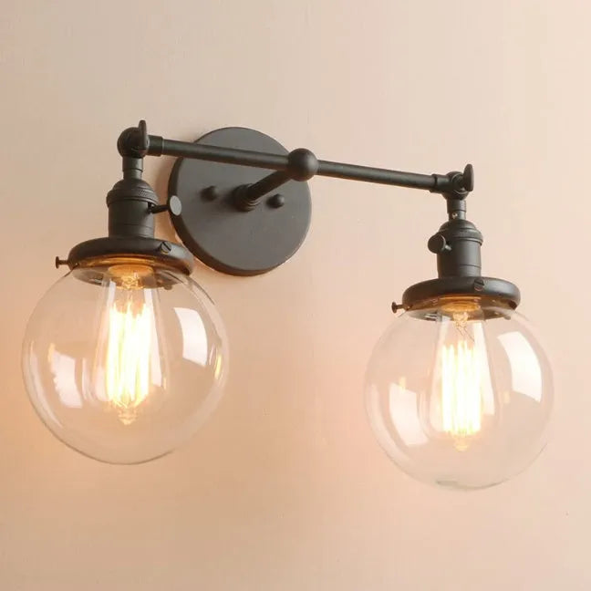 Double headed black iron wall lamp with spherical glass shades on a wall