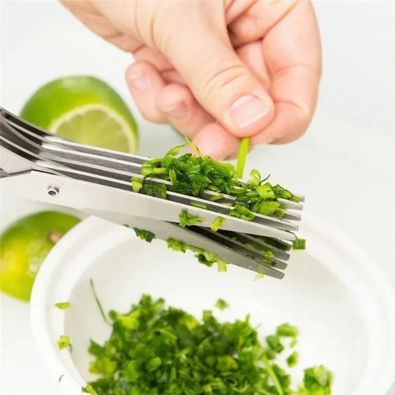 Stainless steel multi-blade kitchen scissors for cutting onions and herbs on a chopping board.