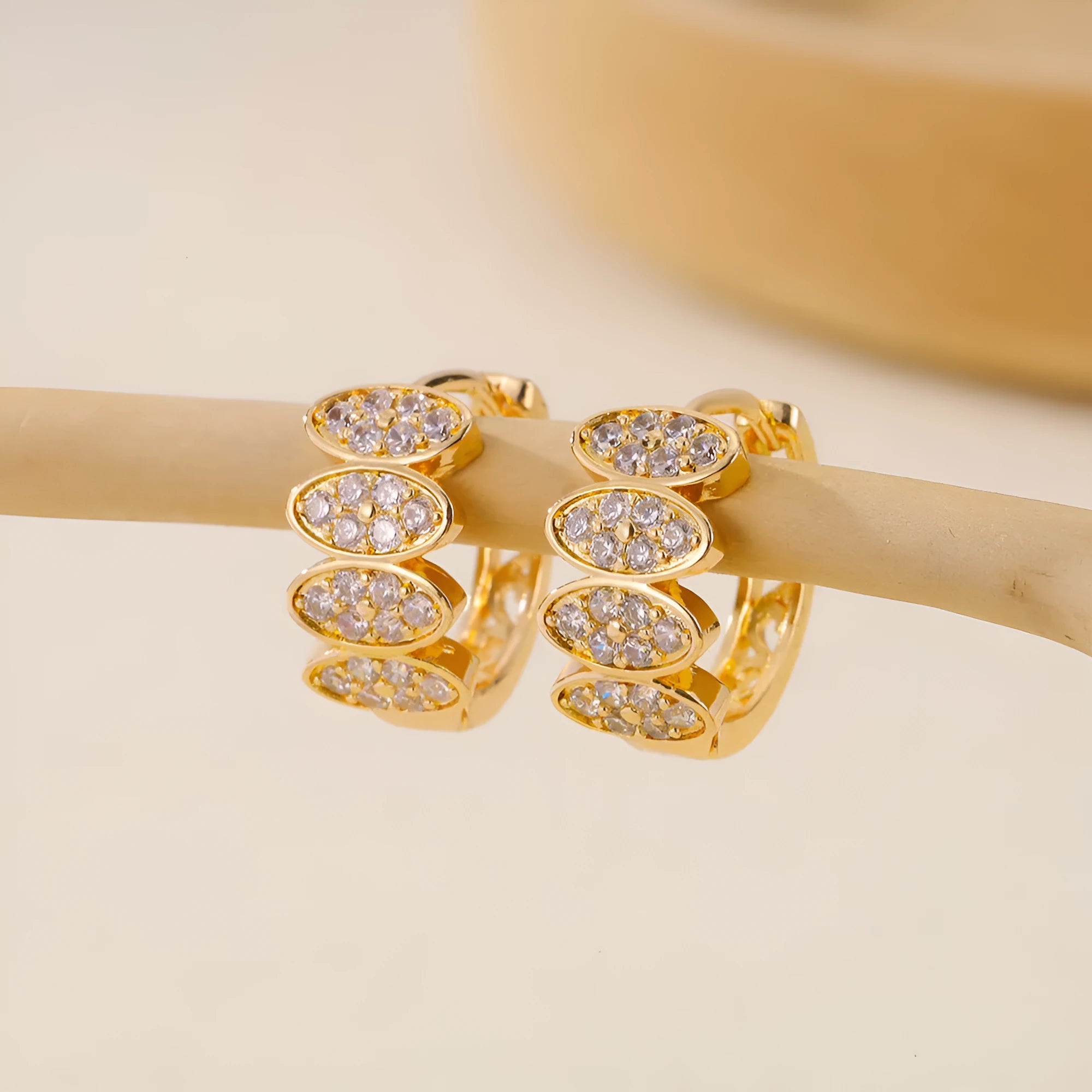 A pair of gold-coloured copper earrings with a zircon stone inlay in an ins style design.