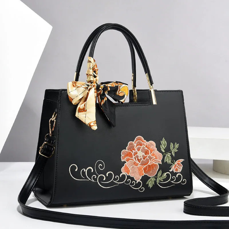Large capacity embroidered women bag in PU, horizontal square shape, with zipper compartments and contrast colour detailing.