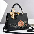 Large capacity embroidered women bag in PU, horizontal square shape, with zipper compartments and contrast colour detailing.