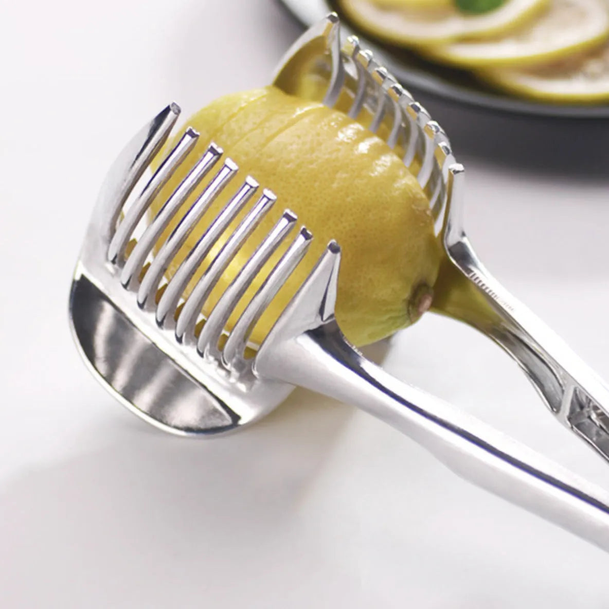 Silver-coloured plastic foldable lemon slicer kitchen gadget for cutting fruits and cakes