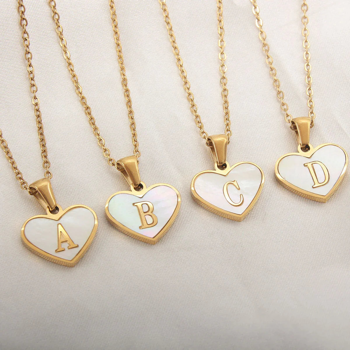 A personalized heart-shaped necklace with a 26-letter charm, crafted from high-quality stainless steel and gold plating.