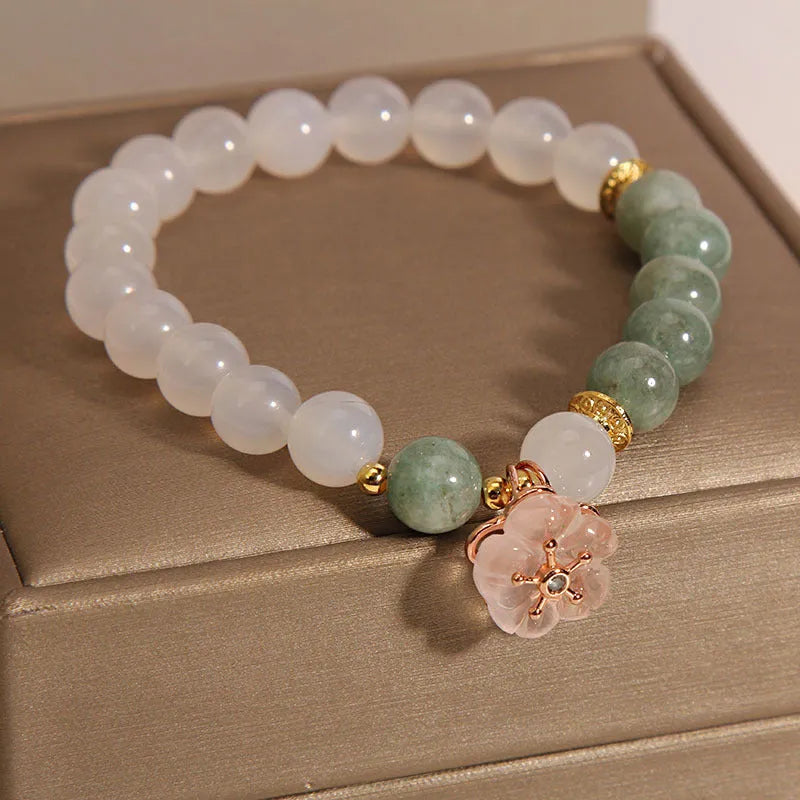 Women's white agate jade bracelet with flower design and pink accents on adjustable sliding knot closure