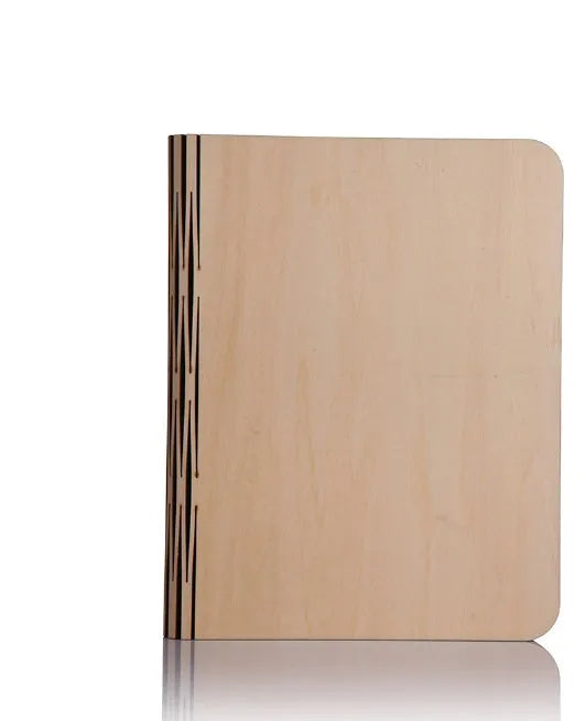 A solid wood adjustable LED book light on a desk next to a book.
