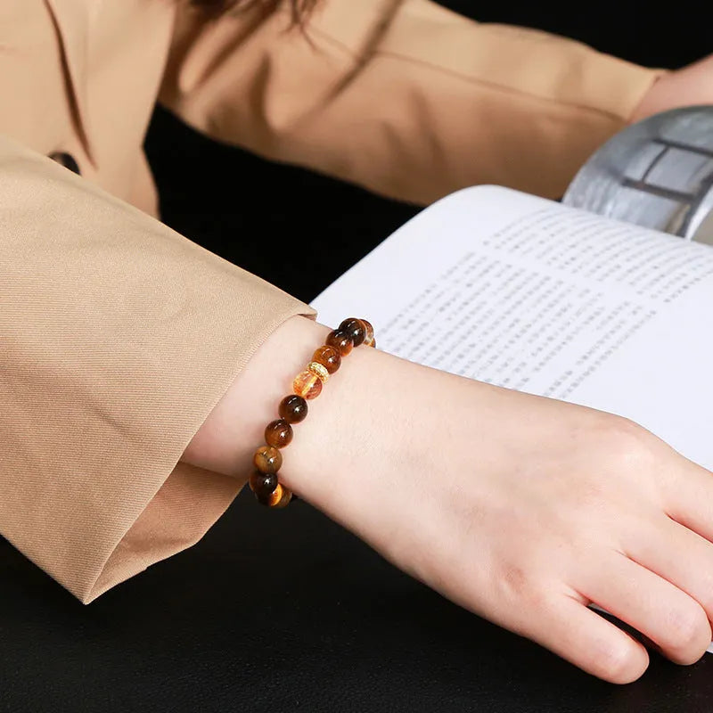 Women's geometric bracelet with natural yellow tiger stone and yellow tower crystal beads on wrist.