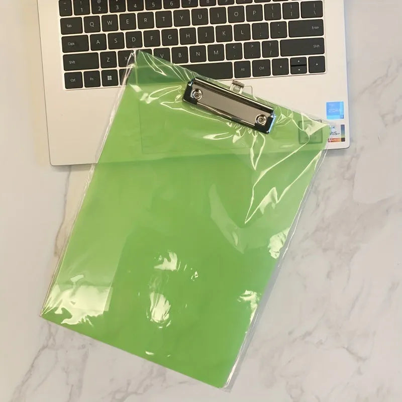 Transparent A4 clipboard with metal clip, shown in blue colour on a wooden desk.