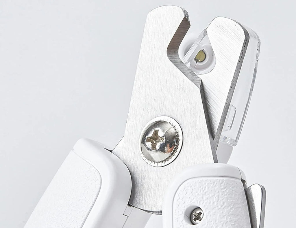 White LED pet nail clippers with a transparent anti-splash guard and an integrated nail file on a grey background.