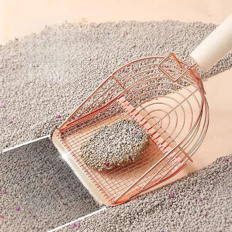 Stainless steel cat litter scoop with a long wooden handle on a litter box.