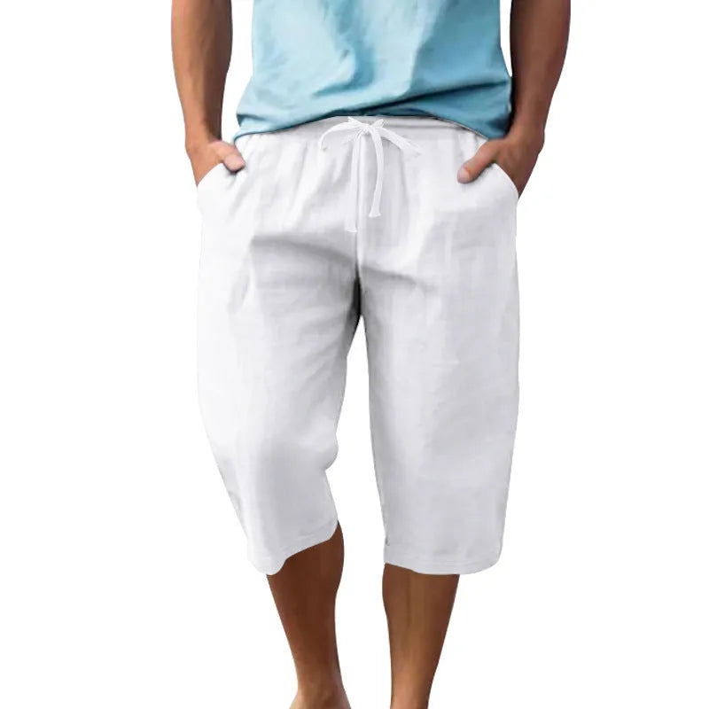 Men's loose linen shorts in light blue with drawstring waist and cropped length on white background