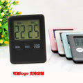 Black and white digital kitchen timer with magnetic strip on back and LCD display.