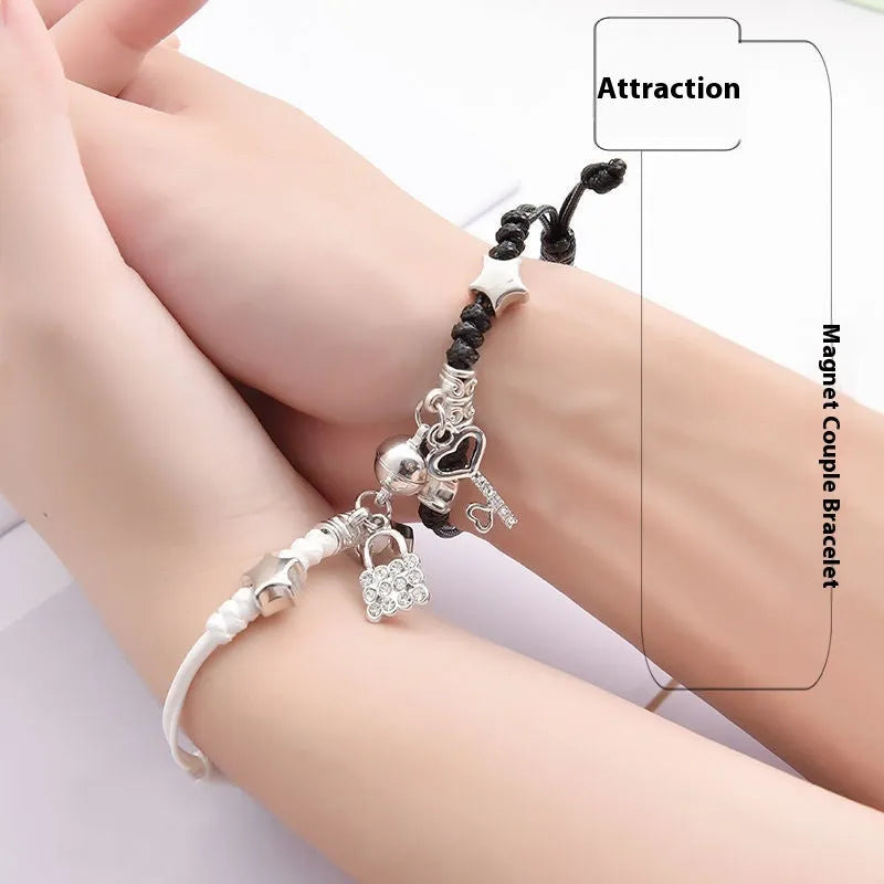 Pair of magnetic alloy bracelets with crown and heart charm designs on a wrist.