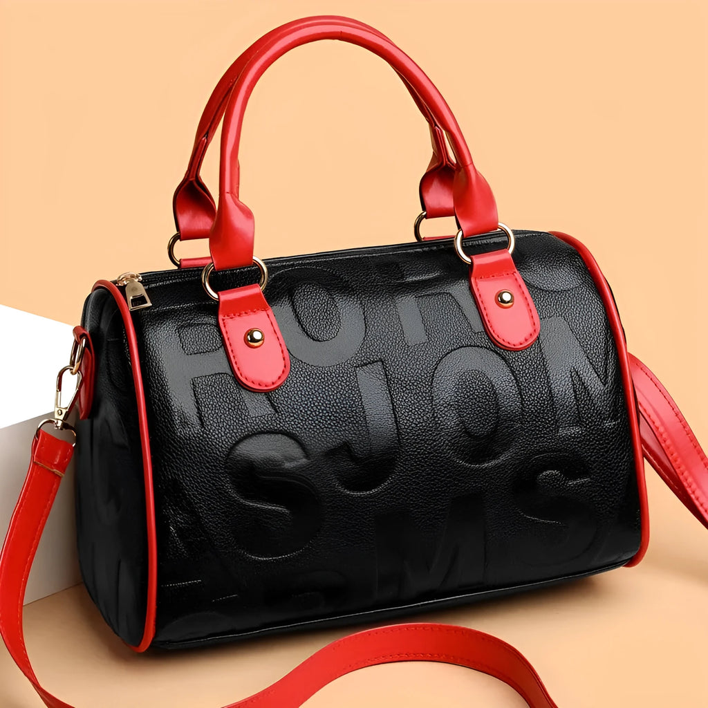 Brown cylindrical leather-effect crossbody bag with three shoulder straps on a table.