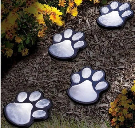 Black solar-powered bear paw-shaped garden light with ground stake and solar panel.