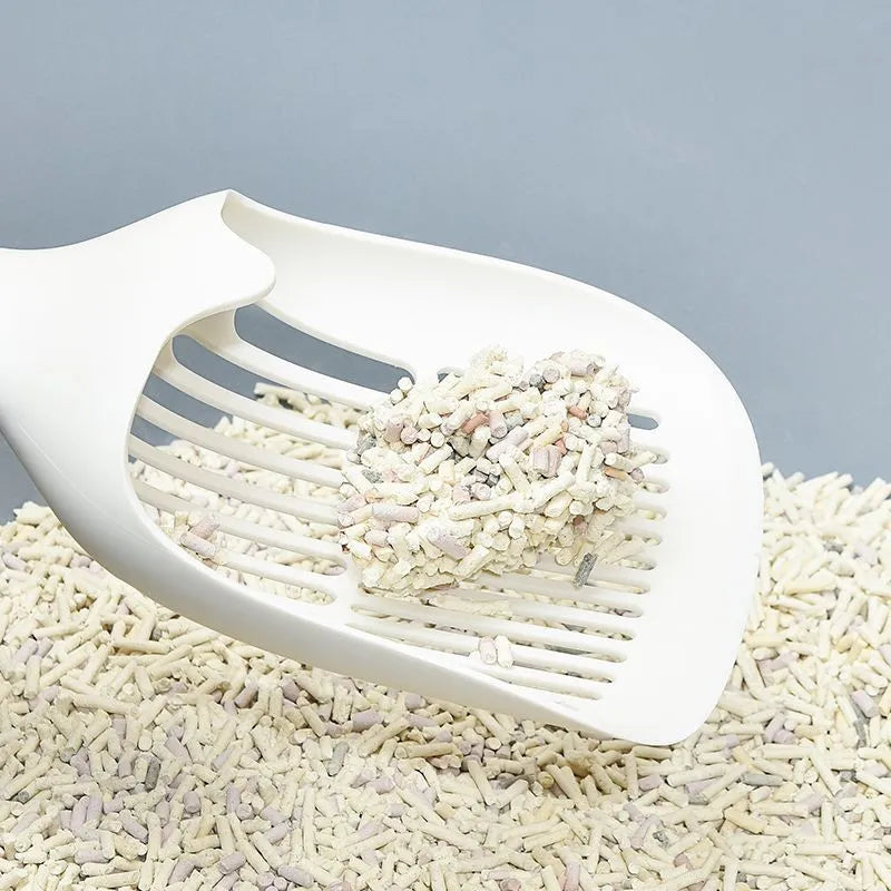 White plastic cat litter scoop sitting in its matching storage base.