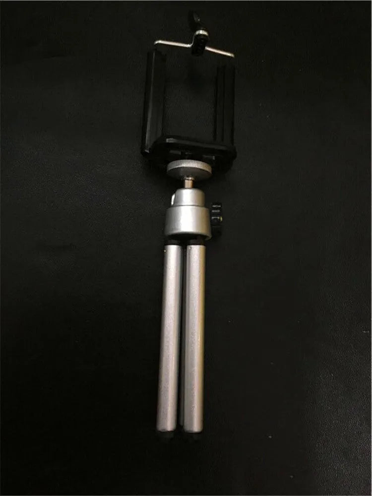 Black adjustable desktop phone stand with two-section bracket on a wooden desk.