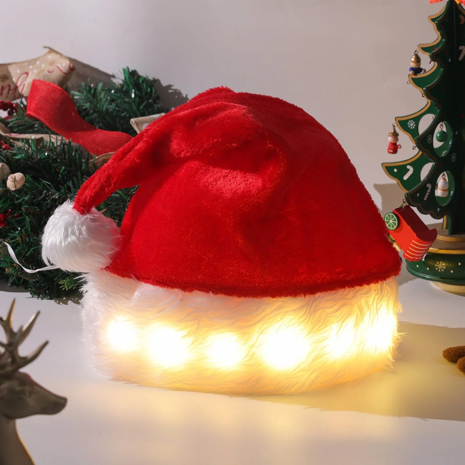 Red and white plush Santa hat with glowing LED lights and a white pom-pom, shown on a person's head.