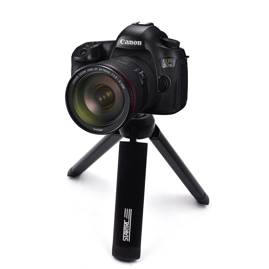 Silver aluminium smartphone bracket for tripod mounting next to a mobile phone.