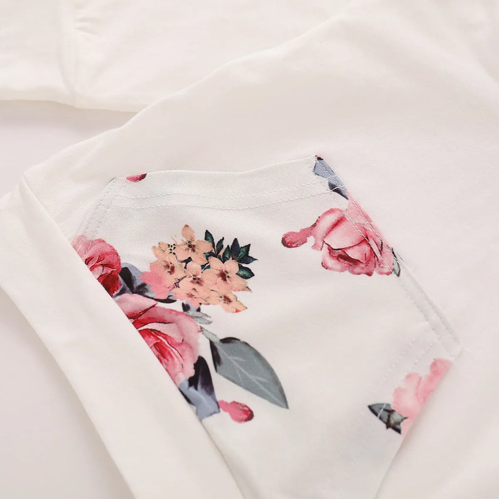 White cotton hooded tracksuit romper for a baby girl, showing long sleeves and full-length trousers.