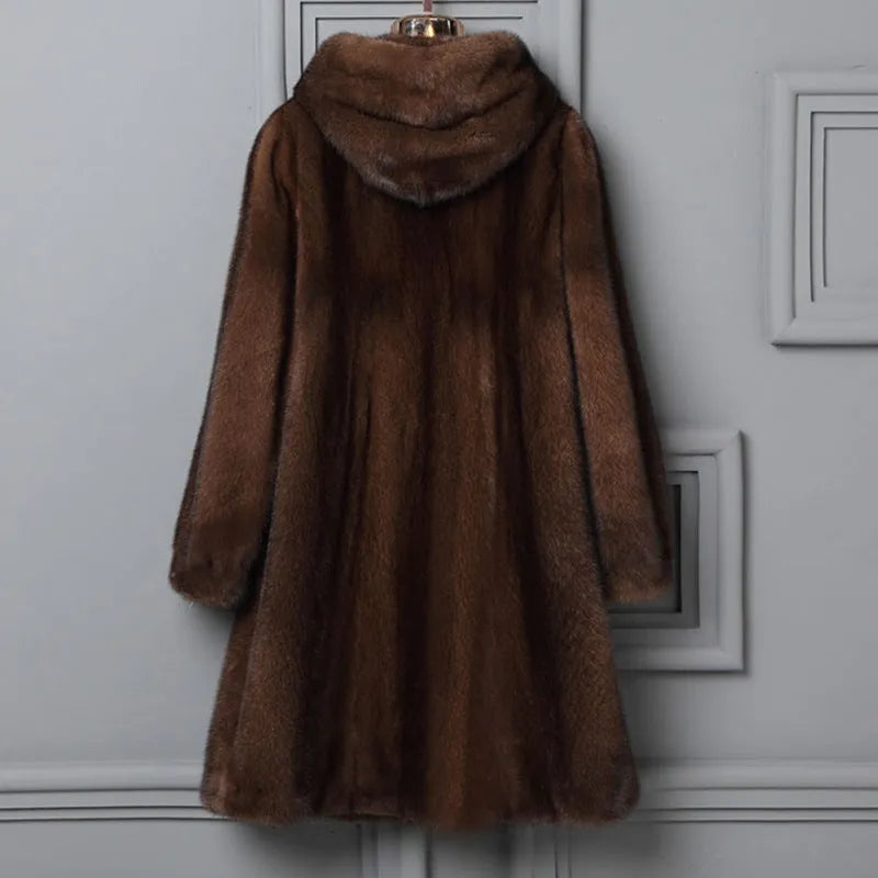 A woman's long black faux fur coat with a hood, shown in a street fashion style.