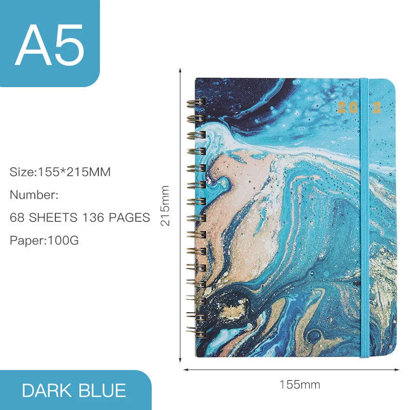 A5 spiral-bound notebook with a colourful floral design cover, lying open on a table.