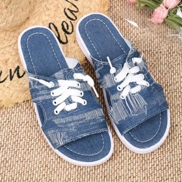 Blue women's flat canvas slippers with a cloth upper and rubber sole.