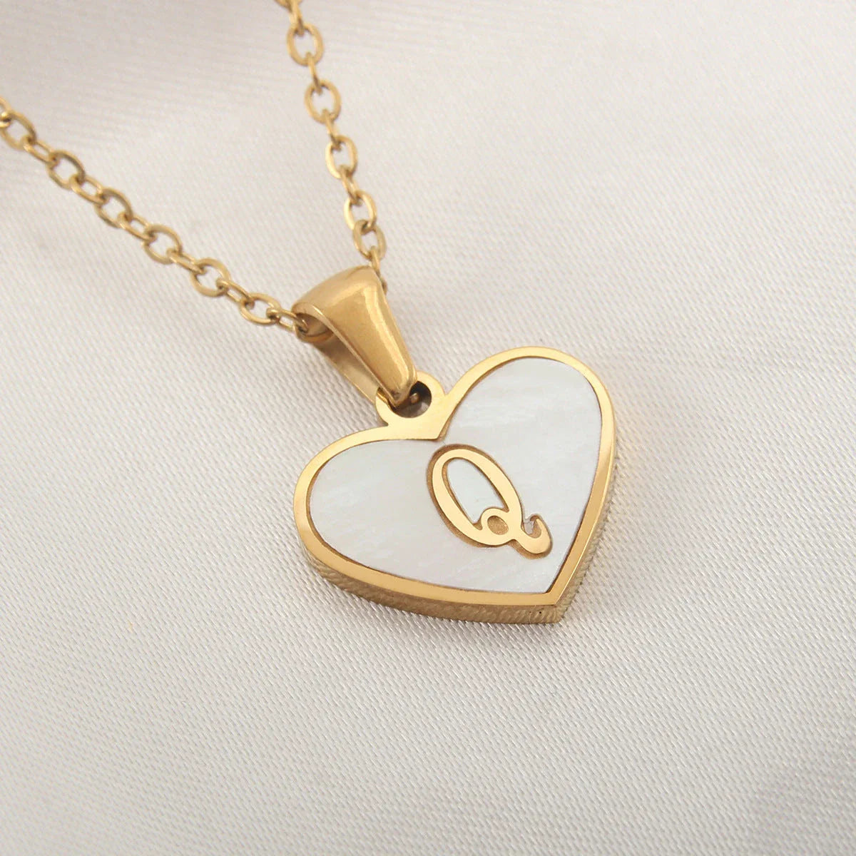 A personalized heart-shaped necklace with a 26-letter charm, crafted from high-quality stainless steel and gold plating.